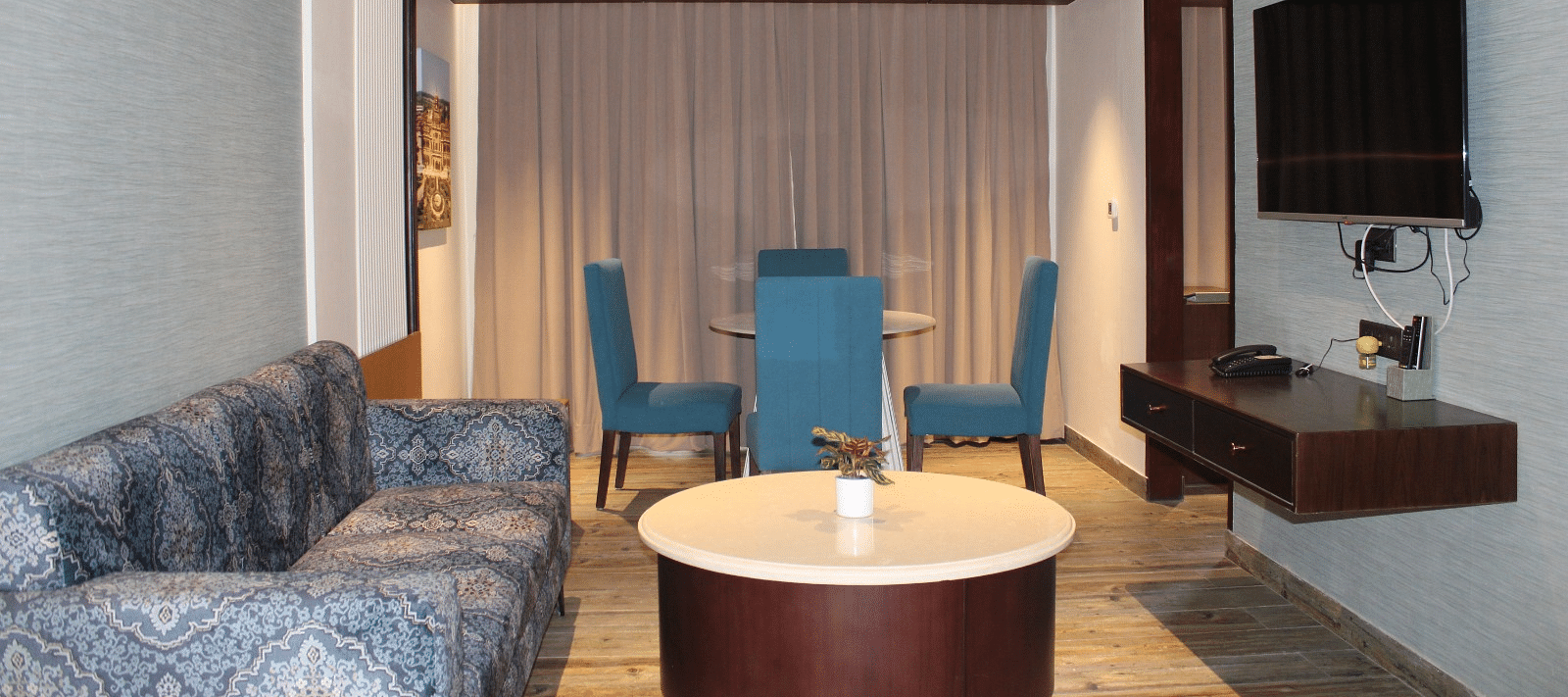 living room of the suite with chairs, a sofa, and a television at BluSalzz Residence, Amritsar